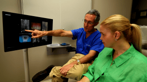 Doctor showing patient scans of teeth
